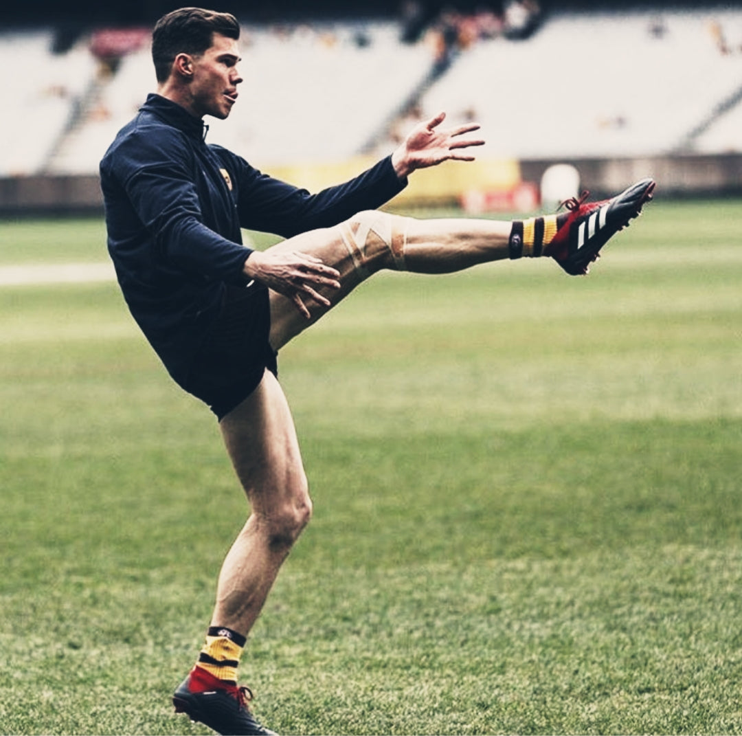 hawthorn afl footballer jaeger o'meara kicking for goal with right knee taped
