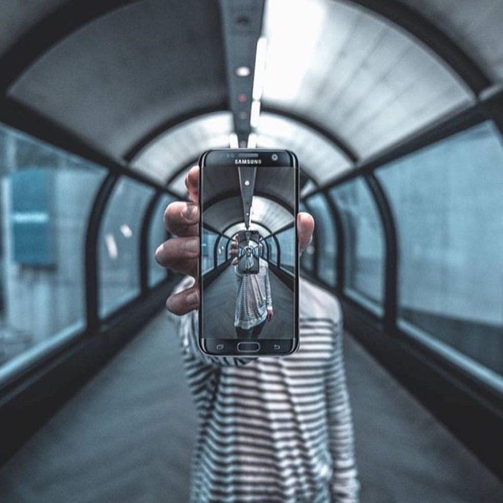 Image of a man holding an iphone depicting why blue light can seriously disrupt sleep