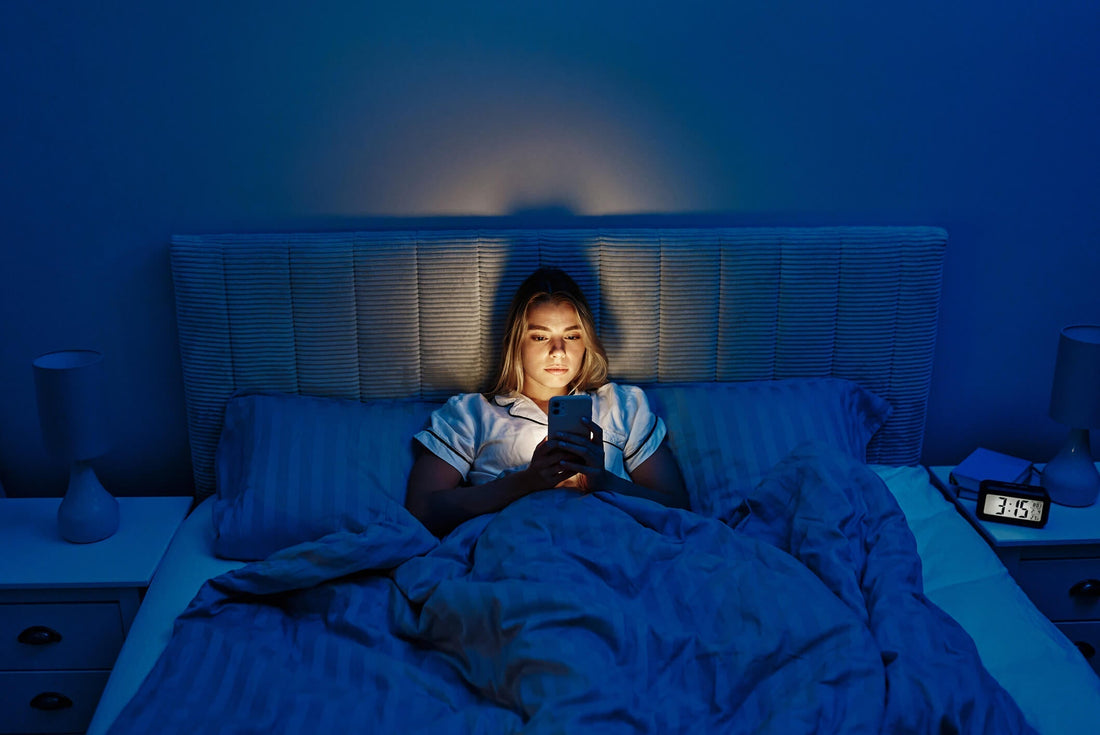 woman using her phone in bed wondering whether blue light is bad for you