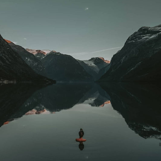 woman immersed in cold water looking at mountains